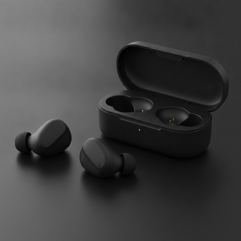 Ecouteurs intra-auriculaires noirs poses a cote de leur boitier de charge noir mat ouvert